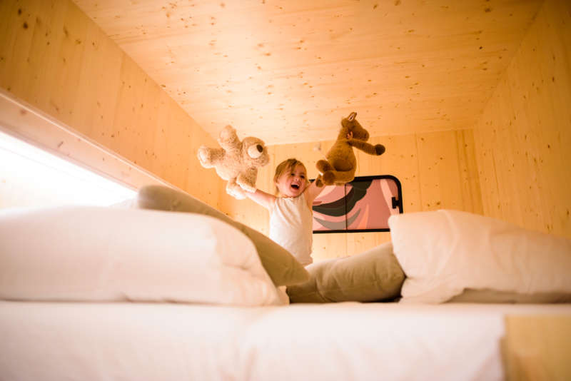 little girl playing on thebed in a private room - The Green Elephant Hostels